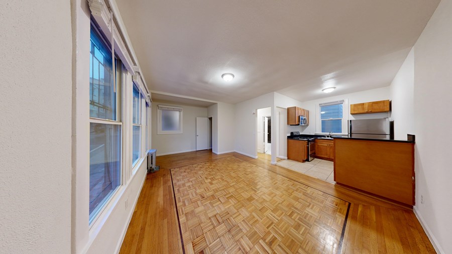 A room with wooden flooring and white walls.